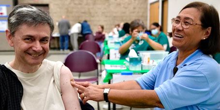 Nurse applying bandage to flu shot vaccine patient